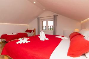 two red and white beds in a room at Apartman Dinko in Bol