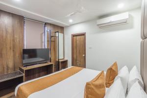 海得拉巴Hotel Kinara Grand的一间卧室配有一张床和一台平面电视