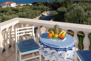 a table with a bowl of fruit on a balcony at Apartman Dinko in Bol