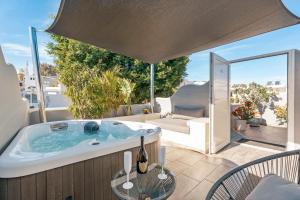 bañera de hidromasaje en el patio de una casa en Oasis Suites Fira, en Fira