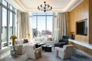 a living room with a couch and chairs and a tv at InterContinental Indianapolis by IHG in Indianapolis