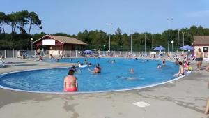a group of people in a swimming pool at Maisonnette au calme, T3, 6 pers résidence avec piscine et wifi privée proche lac et océan in Soustons