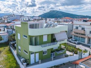 un edificio verde y blanco en una ciudad en Tasos House, en Kremasti