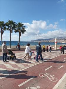 un grupo de personas caminando por una acera cerca de la playa en Casa Tejar, en Almería