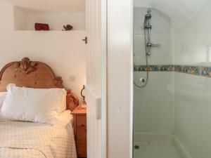 ein Schlafzimmer mit einem Bett und einer Dusche in der Unterkunft Cobblers Cottage in Weymouth + 36 Fotos