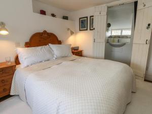 ein Schlafzimmer mit einem großen Bett mit einer weißen Bettdecke in der Unterkunft Cobblers Cottage in Weymouth