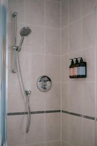 a shower with a shower head in a bathroom at Gamekeeper's Cottage in Banchory