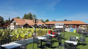 a group of tables and chairs in a yard with at Jolie mobilhome 331 in Gastes