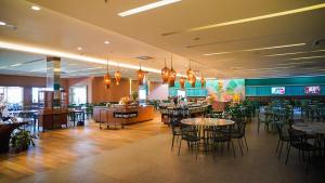 a dining room with tables and chairs and a restaurant at Hot Beach Suites in Olímpia