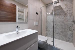 a bathroom with a shower and a sink and a toilet at Hotel Bellavista in Tignale