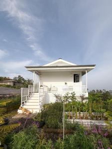 una casa blanca con un porche y escaleras blancas en Querencia Cabin, en Gitgit 22 fotos más