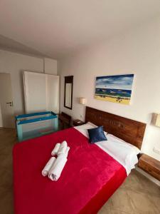 a bedroom with a red bed with two towels on it at Brisa Tropical in Santa Maria