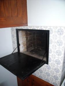 un comptoir noir avec une cheminée en briques sur un mur dans l'établissement Capriga, à Arès
