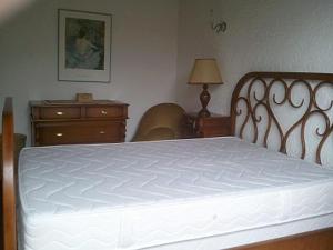 une chambre avec un lit blanc et une commode dans l'établissement Capriga, à Arès 3 autres photos