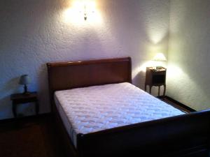 - une chambre avec un lit et une table de nuit avec une lampe dans l'établissement Capriga, à Arès
