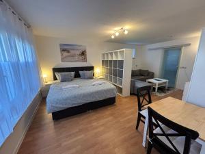 Un dormitorio con una cama, un sofá y una mesa. en Haus Ostseesprung - Fewo Valentina im Souterrain mit Terrasse und gem Garten, en Bad Doberan