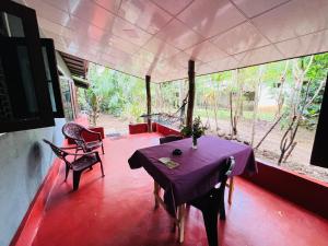 a dining room with a purple table and chairs at Green Grass Homestay in Sigiriya