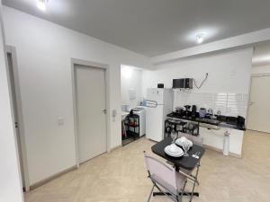 a white room with a table and a kitchen at LK Centro 6 in Belo Horizonte