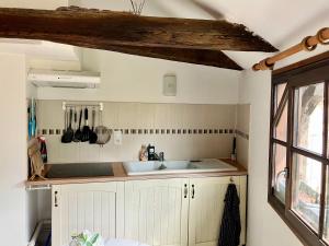 a kitchen with white cabinets and a sink at Paloma in Figeac +12 photos