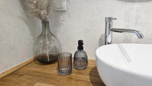 ein Badezimmer mit einem Waschbecken und einer Vase auf dem Tisch in der Unterkunft Nova Letnica Sea Apartaments in Gdańsk Letnica