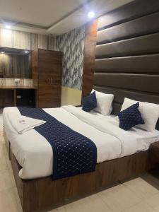 a large bed with blue and white pillows on it at Hotel Hanuwant Palace in New Delhi
