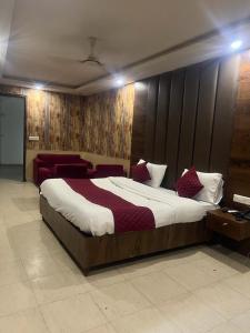 a bedroom with a large bed and red chairs at Hotel Hanuwant Palace in New Delhi