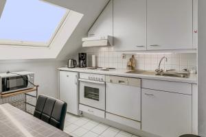 科克赛德Zeezonzand 0202的厨房配有白色橱柜、水槽和微波炉 更多11张照片