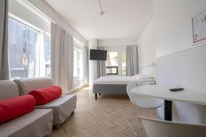 a white room with a bed and a couch and a table at Omena Hotel Turku Kauppiaskatu in Turku