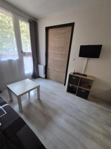 a living room with a table and a sliding door at Résidence les Mélèzets 2 au pieds des pistes et des commerces in Modane