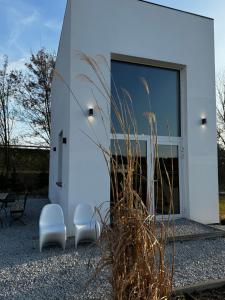 a white house with two chairs and a window at Awangarda in Trzciel +7 photos