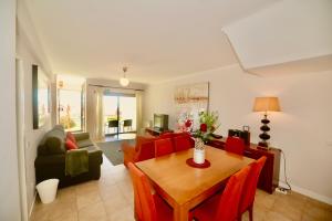 a living room with a table and red chairs at Bay in São Martinho do Porto