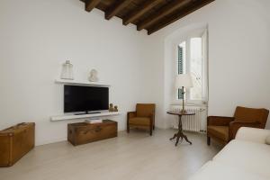 a living room with a bed and a tv at Chez Amèlie in La Spezia