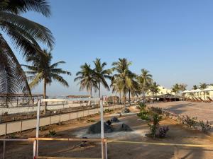 une plage avec des palmiers et un groupe d'animaux dans l'établissement Samharam Resort Salalah, à Salalah