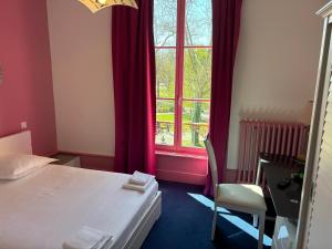 a bedroom with a bed and a desk and a window at Hotel Couleurs Sud Centre-ville Gare Charleville-Mézières in Charleville-Mézières +196 photos