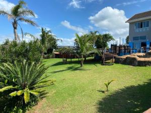 a yard with palm trees and a building at BlueSkyMining in Kingsborough