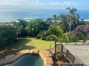 a swimming pool next to a wooden deck and the ocean at BlueSkyMining in Kingsborough