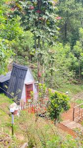 a small house with a door in a garden at Alpine Kanthalloor CAMP SITE in Kanthalloor