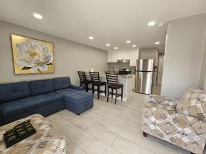 a living room with a blue couch and a kitchen at Charming Forest Apartment in Lumberton