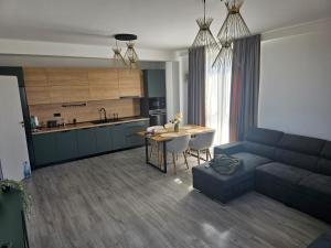 a living room with a couch and a table and a kitchen at Apartament Palace Baile Felix in Baile Felix