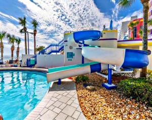 a water slide next to a pool at a resort at Wyndham Ocean Walk Resort - Vacation in Comfort by the sea - 2BR Oceanview 24320 in Daytona Beach