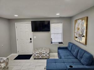 a living room with a blue couch and a flat screen tv at Charming Forest Apartment in Lumberton