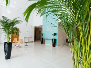 eine Lobby mit Topfpflanzen in einem Gebäude in der Unterkunft Ibis Abu Dhabi Gate in Abu Dhabi + 37 Fotos