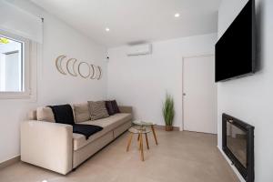 Una sala de estar con un sofá y un televisor de pantalla plana. en Meraki2-Picina cubierta climatizada, en Novo Sancti Petri