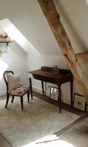 a wooden desk in a room with a chair at La clé des jardins in Nouâtre