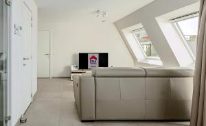a living room with a couch and a tv at Villa Zephir O3O5G 221 in Nieuwpoort