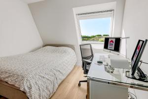 a bedroom with a bed and a desk with a computer at Villa Zephir O3O5G 221 in Nieuwpoort +7 photos