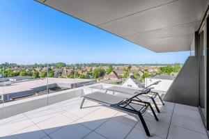a chair on a balcony with a view of the city at Villa Zephir O3O5G 221 in Nieuwpoort