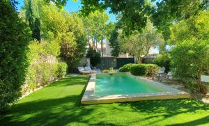 a backyard with a swimming pool in the grass at Maison d'hôtes La Bastide de Patou in Marseille