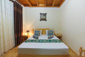 Un dormitorio con una cama blanca con dos almohadas. en Boutique Hotel Shakhrut, en Bukhara