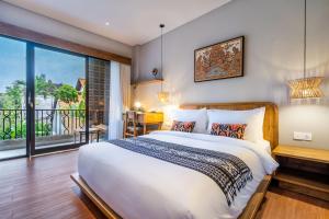 a bedroom with a large bed and a large window at Arusa Home Bali - Luxury Private Suites Canggu in Canggu